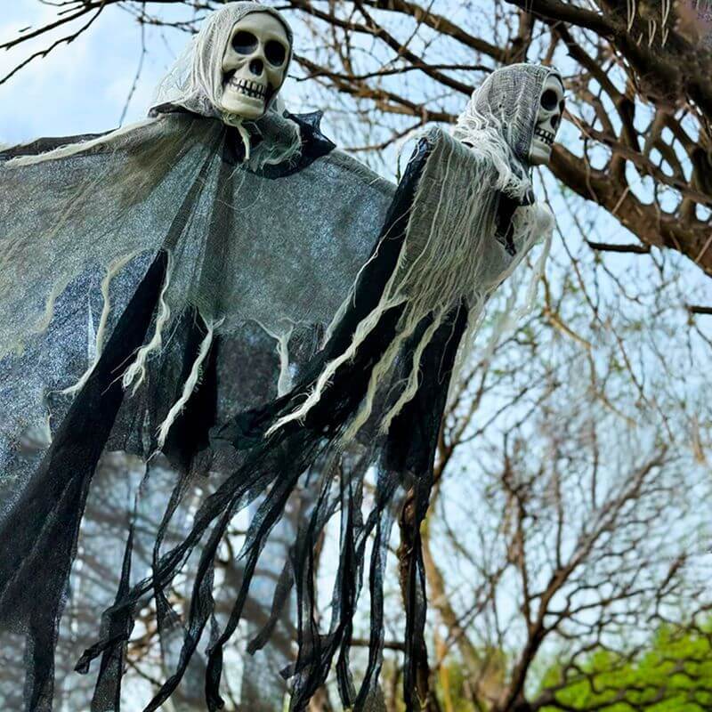 Halloween decorations featuring hanging ghost skull skeleton props for outdoor yard festival decor.