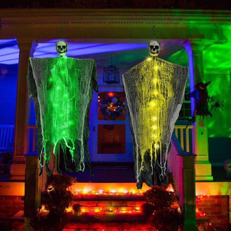 Halloween decorations featuring hanging ghost skull skeleton props in green and yellow lights for home outdoor festival